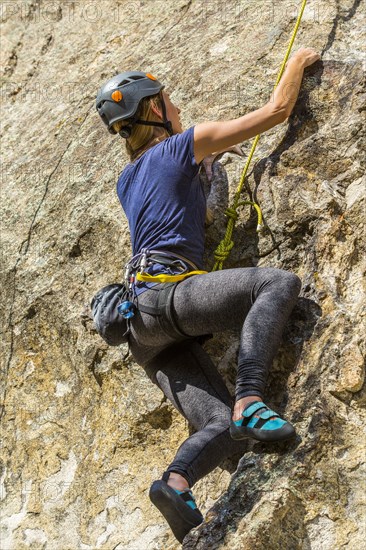 Caucasian woman climbing rock