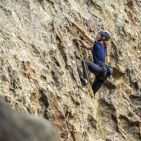 Caucasian woman climbing rock