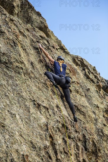 Caucasian woman climbing rock