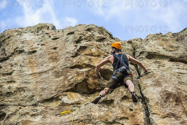 Caucasian man climbing rock