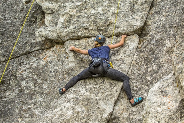 Caucasian woman climbing rock