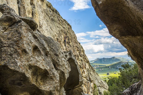 Distant Caucasian woman climbing rock