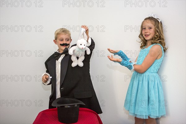 Caucasian magician pulling rabbit from hat