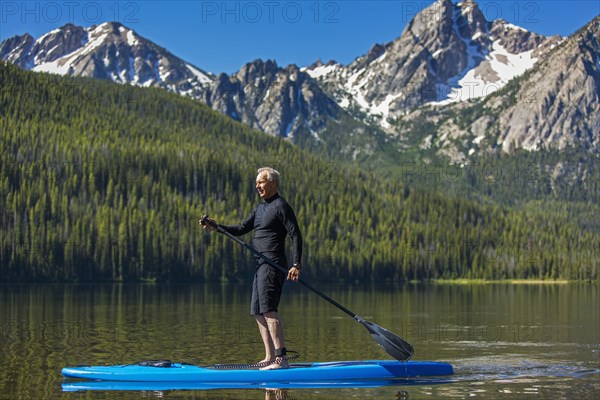 Caucasian man on paddleboard on mountain lake