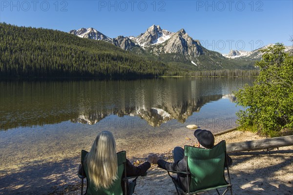 Caucasian couple holding hands at mountain lake