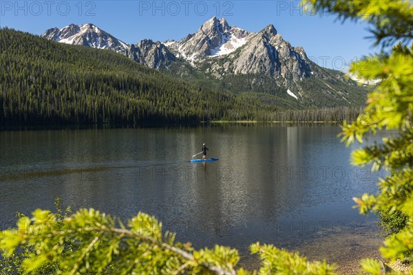 Caucasian man on paddleboard on mountain lake