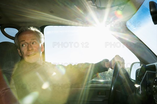 Caucasian man driving car looking back