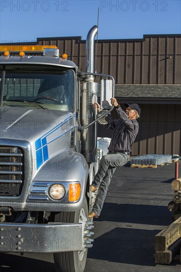 Caucasian man climbing into semi-truck