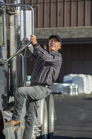 Caucasian man climbing into semi-truck