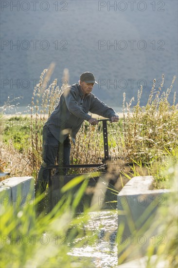 Caucasian farmer adjusting irrigation equipment