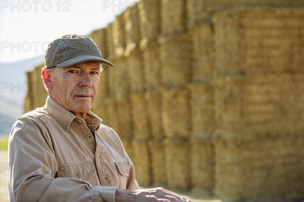 Caucasian farmer near stacks of hay