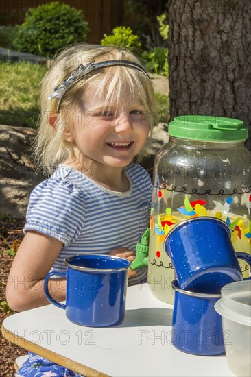 Smiling Caucasian girl selling lemonade