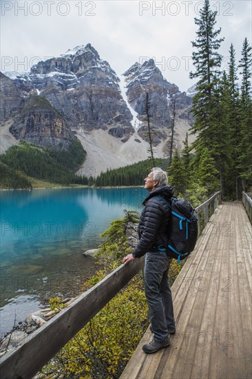 Caucasian man standing on boardwalk admiring mountain