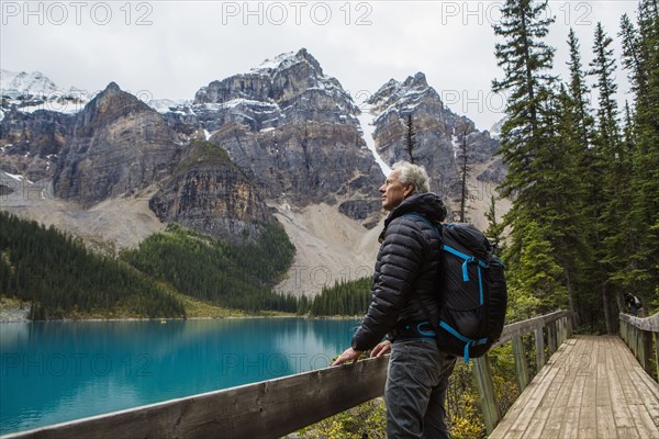 Caucasian man standing on boardwalk admiring mountain