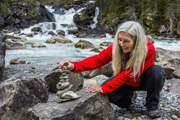 Caucasian woman balancing stack of rocks