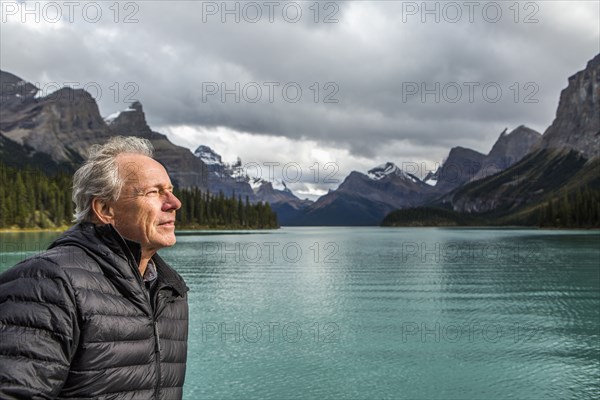 Caucasian man standing near mountain lake