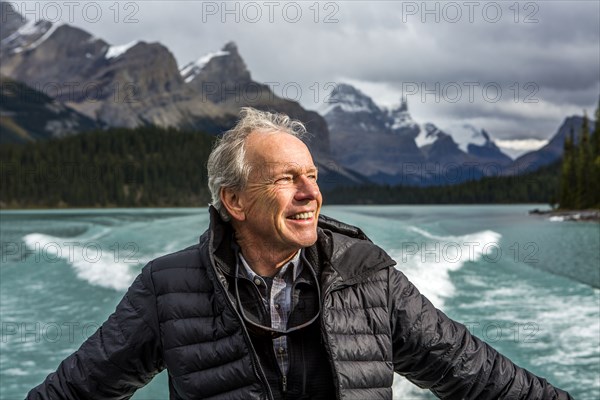 Caucasian man on boat in mountain lake