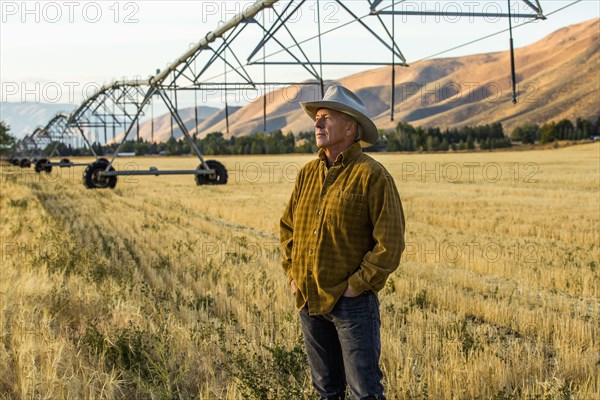 Caucasian farmer standing near irrigation equipment