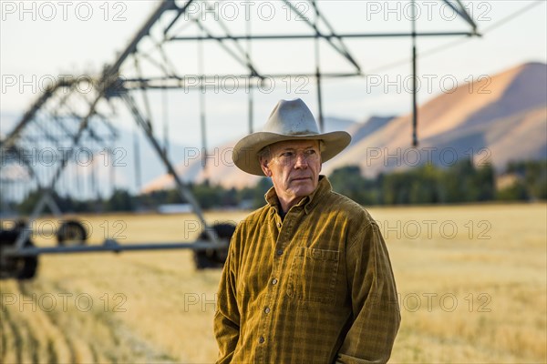 Caucasian farmer standing near irrigation equipment