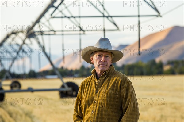 Caucasian farmer standing near irrigation equipment