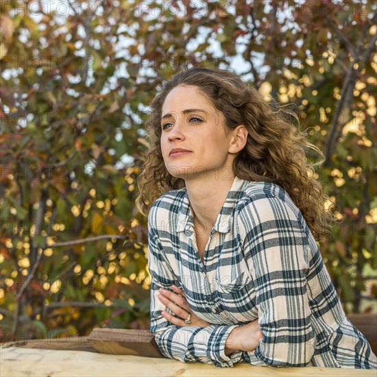 Caucasian woman leaning on wooden fence