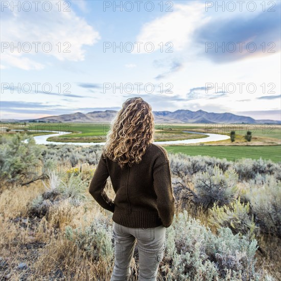 Caucasian woman standing near winding river