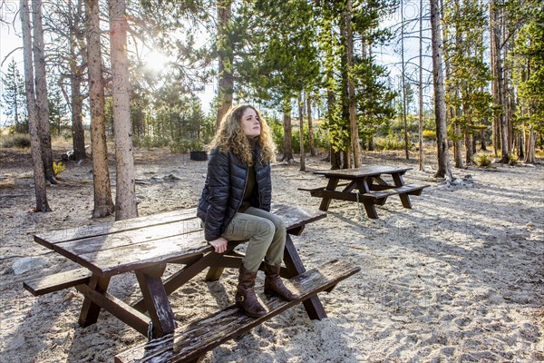 Caucasian woman sitting on picnic table