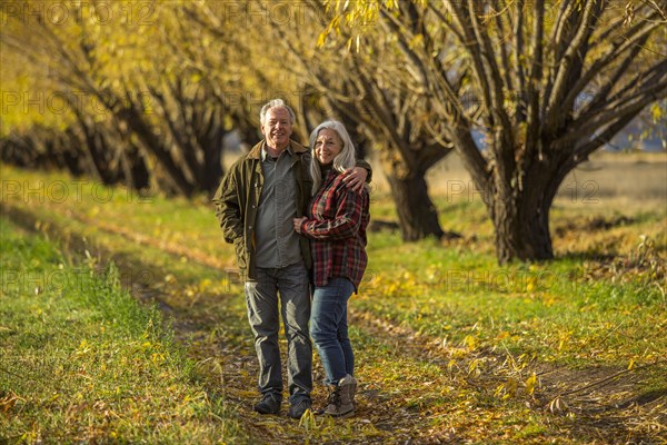 Caucasian couple hugging near trees in autumn