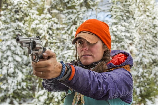 Caucasian woman aiming handgun in winter