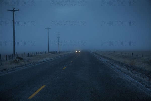 Car approaching on icy two-lane road