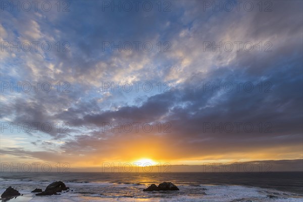 Rocks in ocean at sunset