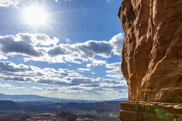 Caucasian woman hiking on ledge of cliff