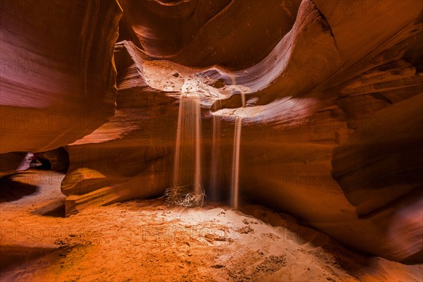 Sand pouring from wall of rock formation