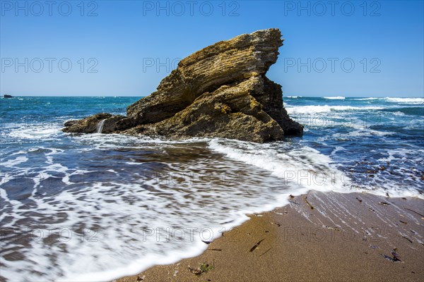 Waves splashing on rock at ocean beach