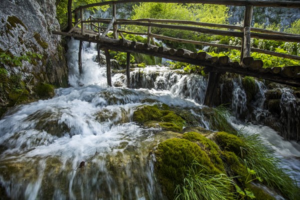 Wooden footbridge over waterfall