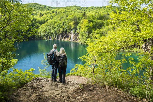 Older Caucasian couple admiring waterfall