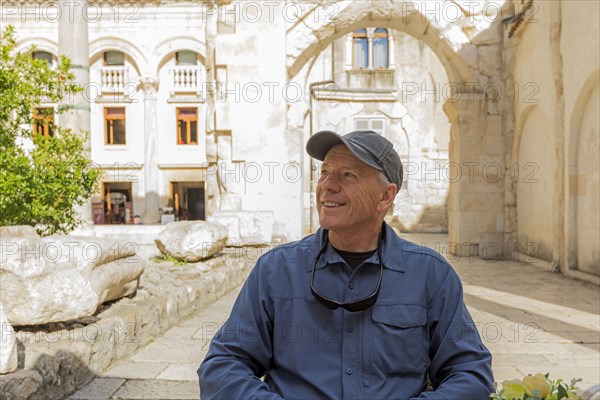 Smiling older Caucasian man sitting in garden