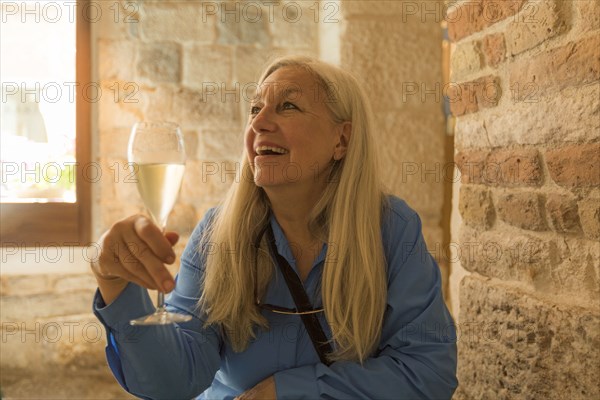 Older Caucasian woman drinking white wine