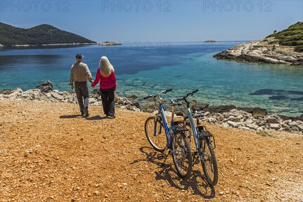 Caucasian couple holding hands near lake