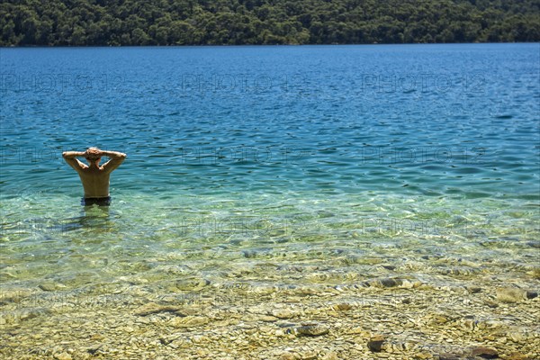 Caucasian man wading in water