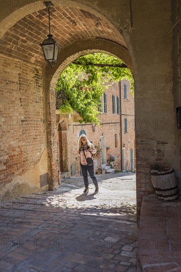 Caucasian woman under arch over sidewalk