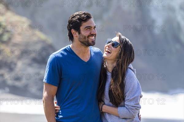 Couple laughing and hugging on beach