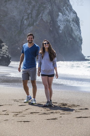 Couple holding hands and walking on beach