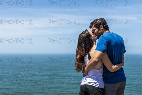 Couple kissing near ocean