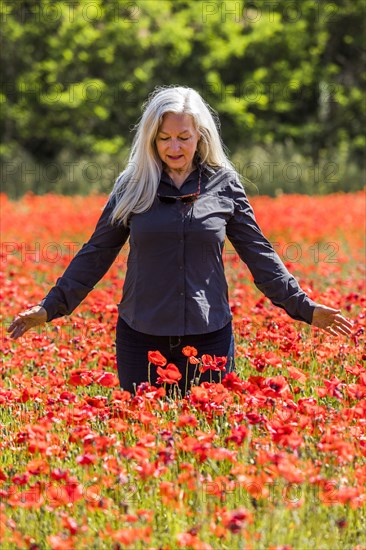 Caucasian woman looking down at field of flowers