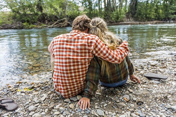 Caucasian couple holding at river