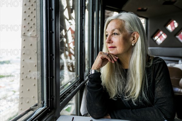 Caucasian woman admiring scenic view from restaurant window