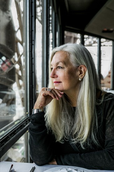 Caucasian woman admiring scenic view from restaurant window