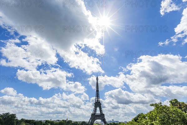 Sunbeams over distant Eiffel Tower