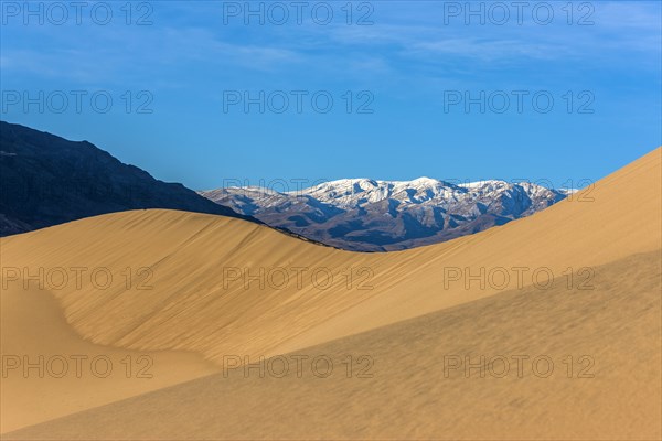 Sand dunes near snowy mountain range